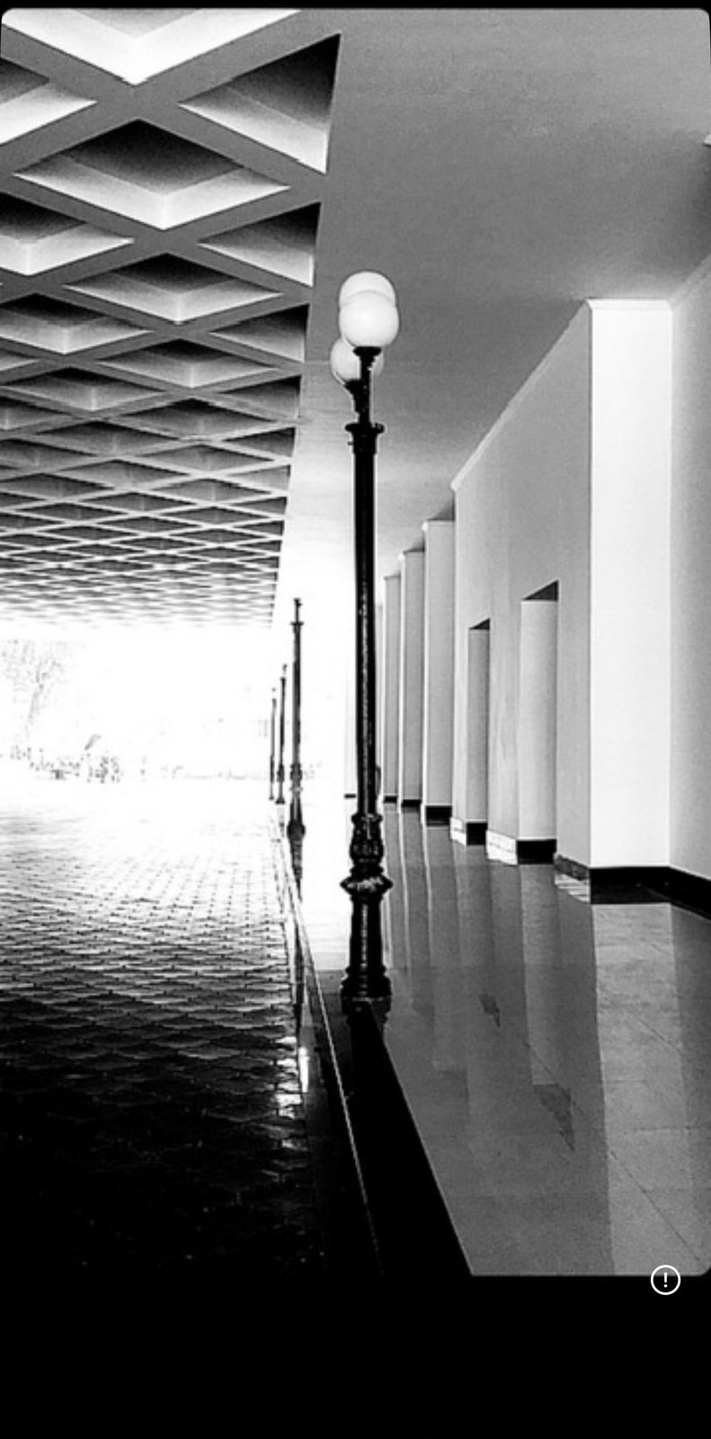A long black-and-white corridor after rain in Delhi