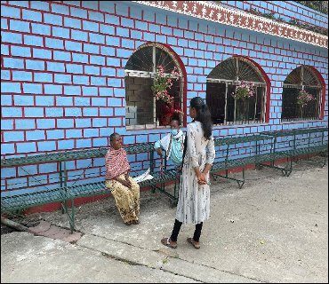 A field interview taking place beneath a veranda in Jharkhand